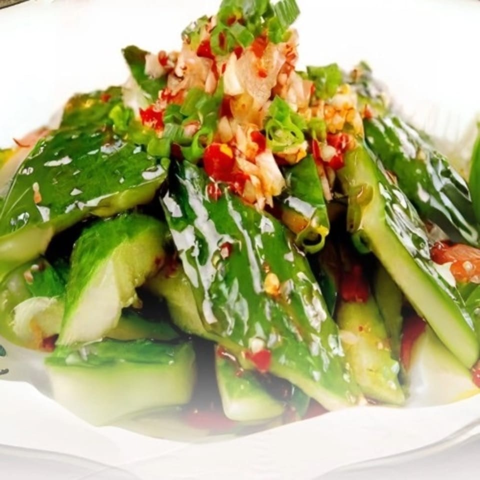 Close-up of Miss Sichuan's smashed cucumber salad, topped with chopped red chilies and green onions.